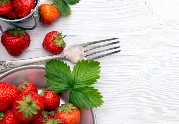 istock Strawberries in a bowl on rustic wood 972341854