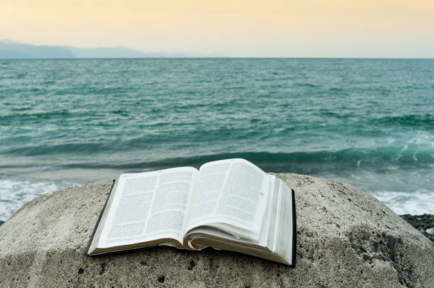 istock Bible open on top of a rock. 972349886