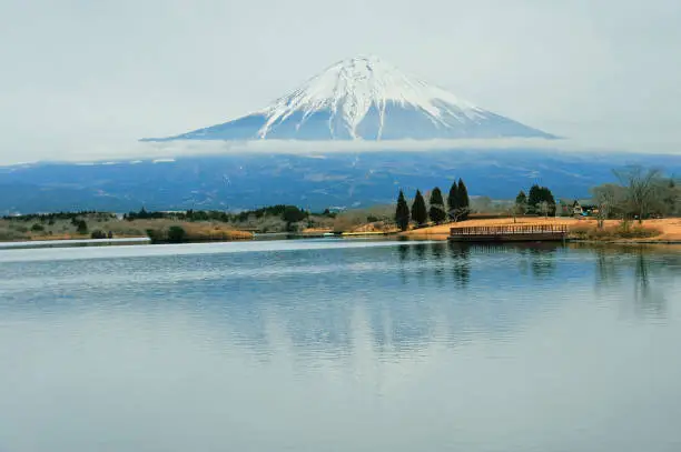 Wonderful view of Mount Fuji in Lake Tanuki an overcast afternoon with gray sky. Japan.