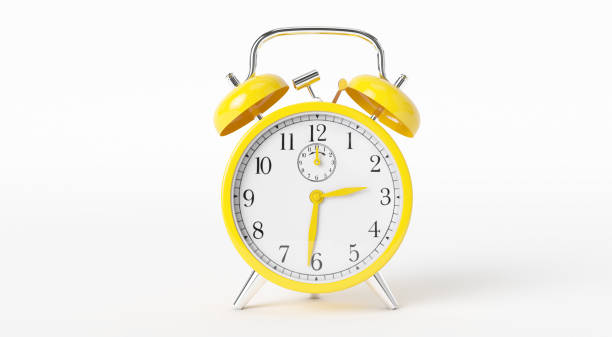istock yellow retro alarm clock on isolated background. 972355628