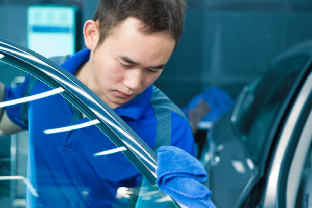 istock Worker  wipes the car door with  rag 972384338