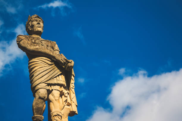 istock Stone statue of a man with cloudy blue sky background 972386558