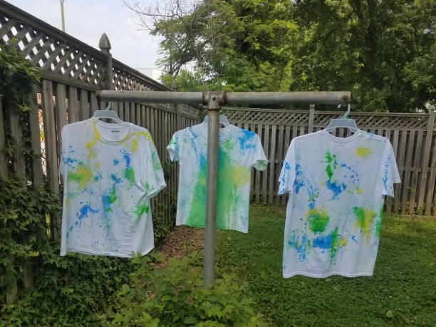 istock white shirts with paint hanging to dry 972389070