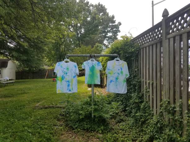 istock white shirts with paint hanging to dry 972390434