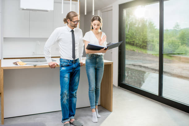 istock Young couple with book in the modern kitchen interior 972472970