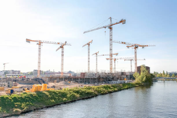 grande cantiere con molte gru su un fiume, in una giornata soleggiata e confusa - berlino 2018 - berlin germany architecture bridge germany foto e immagini stock