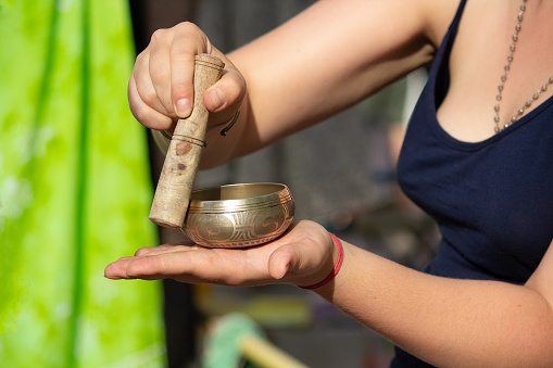 Singing bowl with Buddhist mantra in woman's hand