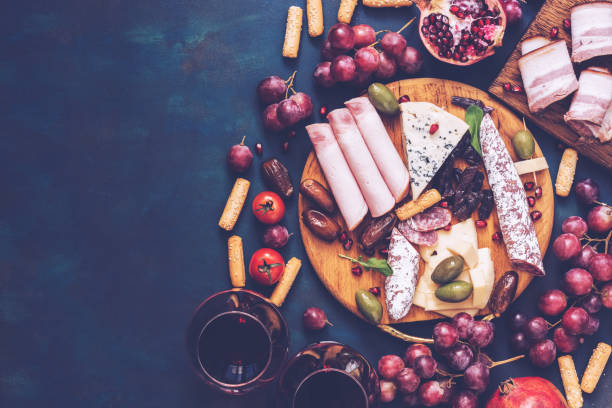 istock Various snacks-fruit, cheese,sausage, red wine. Top view, copy space. Toned photo. 972489630