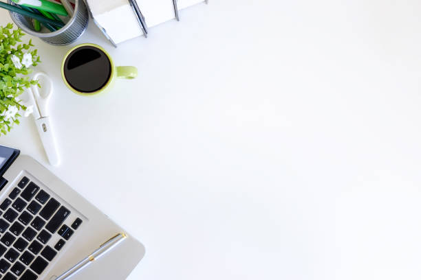 istock Office desk with workspace laptop computer, coffee cup and book on white table with top view. 972492386