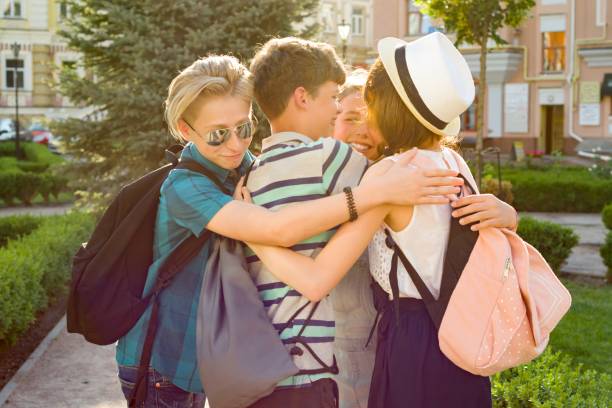 group of happy teenagers 13, 14 years walking along the city street, friends embrace. - 13 14 years teenager school education imagens e fotografias de stock