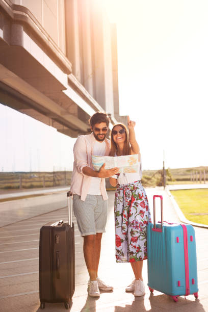 istock Happy tourists sightseeing city with map 972506524