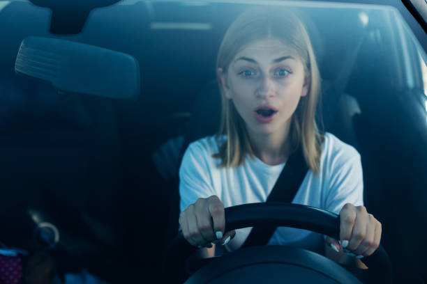 volto spaventoso della donna alla guida dell'auto - driving test foto e immagini stock