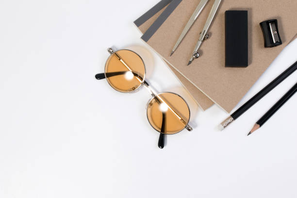 istock Modern white office desk table with pencil, notebook, divider scribe and glasses or office supplies with copy space for text. 972514932
