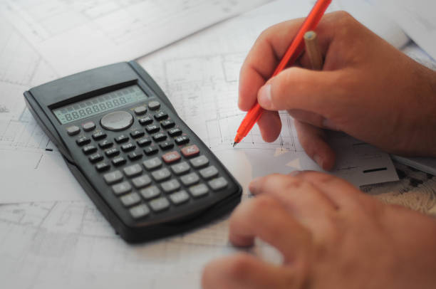 istock Close up of engineers hands working on table, he drawing project sketch in construction site or office 972517490