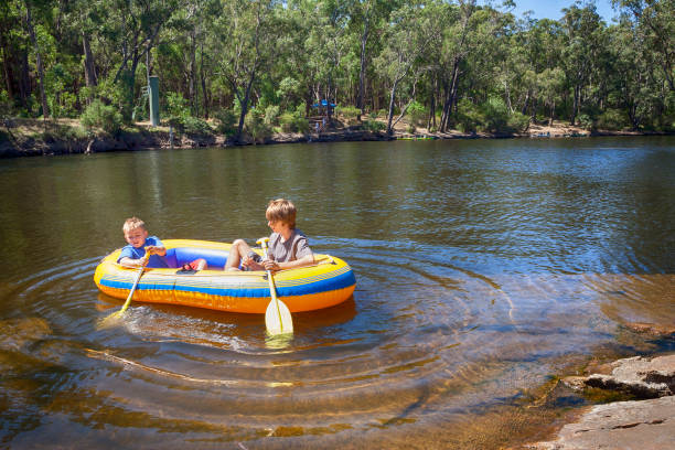 A teenager and a nine year old rafting in a River near Dwellingup Western Australia.