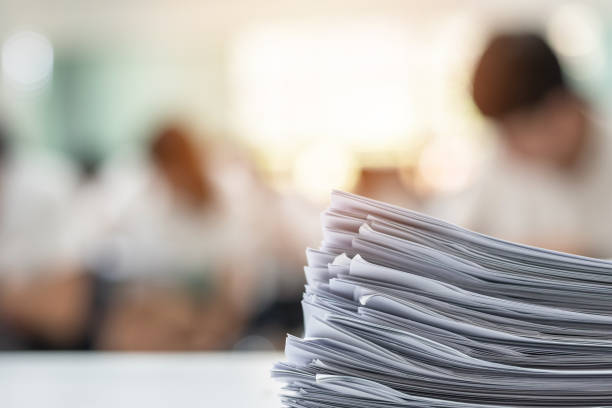 istock Exam answer sheet or application paper blurry view on table in examination room with blur education background of school university students taking exam test writing answer in seat row with stress 972517824