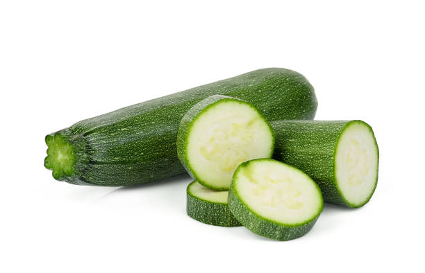 свежий зеленый цуккини с ломтиками изолированы на белом фоне - zucchini vegetable white green стоковые фото и изображения