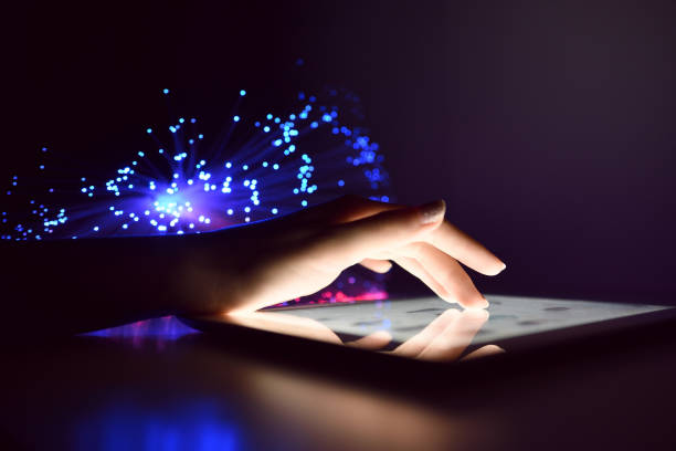 istock Woman Hand Touching Tablet Screen Browsing Internet On Blurry Fiber Optic Bokeh Background Technology Concept Close Up 972523620