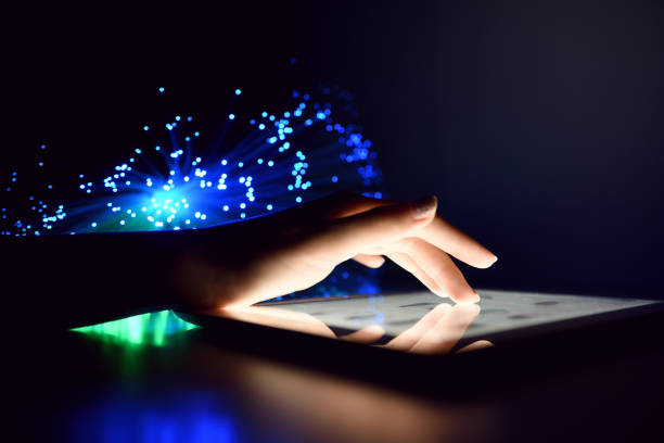 istock Woman Hand Touching Tablet Screen Browsing Internet On Blurry Fiber Optic Bokeh Background Technology Concept Close Up 972523628