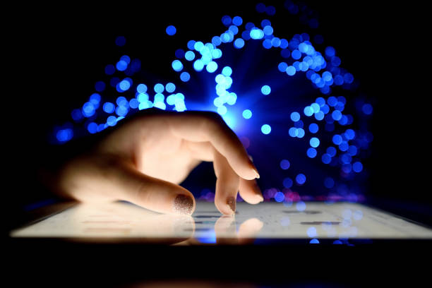 istock Woman Hand Touching Tablet Screen Browsing Internet On Blurry Fiber Optic Bokeh Background Technology Concept Close Up 972523630