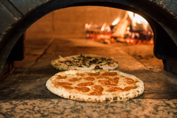 レストランれんが造りのオーブンで焼くイタリアンピザのクローズ アップ表示 - brick oven ストックフォトと画像