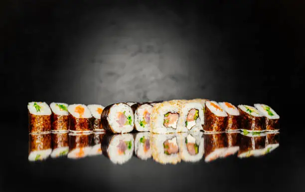 Top view of Japanese Sushi. Sushi rolls set on black dark background. Space for text. Sushi menu. Japanese food. Free-space. Close-up.