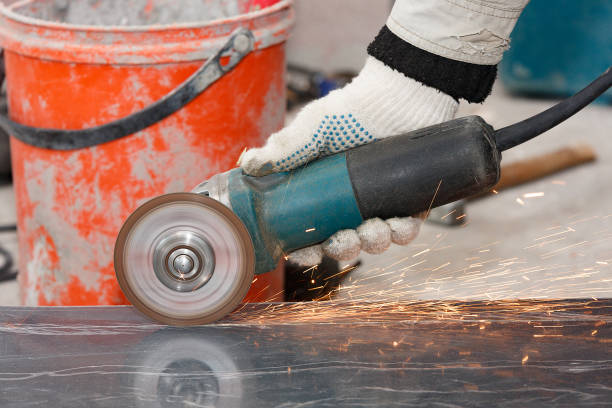 istock The hand of a worker in a glove cuts the building material with an angular grinding machine, creating sparks. 972529498