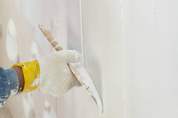 istock Hand with a spatula in the process of leveling the raw plaster. 972532004