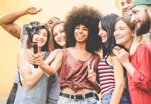 Happy millennials friends making video feed with smartphone outdoor - Young people having fun with new technology trends - Youth lifestyle and social media concept - Focus on black african girl face