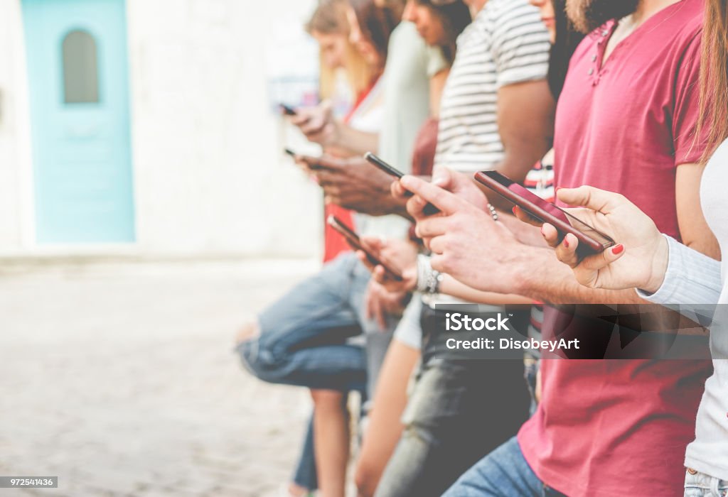 Group of friends watching smart mobile phones - Teenagers addiction to new technology trends - Concept of youth, tech, social and friendship - Focus on close-up phone Mobile Phone Stock Photo