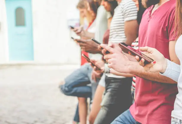 Photo of Group of friends watching smart mobile phones - Teenagers addiction to new technology trends - Concept of youth, tech, social and friendship - Focus on close-up phone