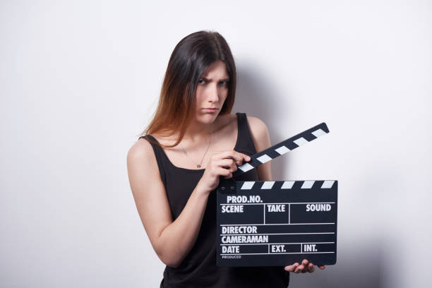 istock Brooding serious female holding movie clapper board 972547450