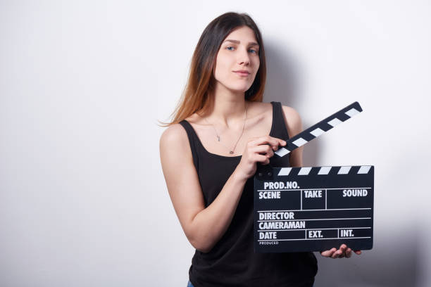 istock Confident female with movie clapper board 972547482