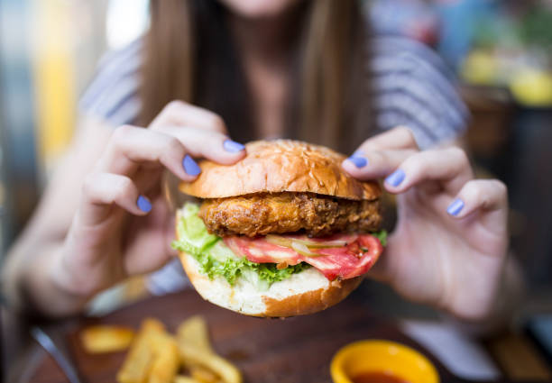 istock woman holding a big hamburger 972550984