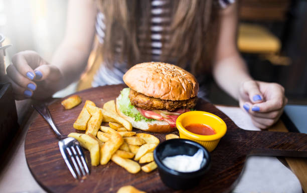 woman eating burger in restaurant