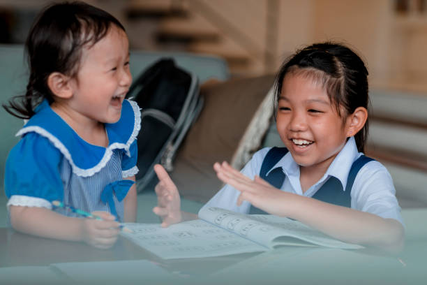 istock Older sister helps younger sister with homework 972553542
