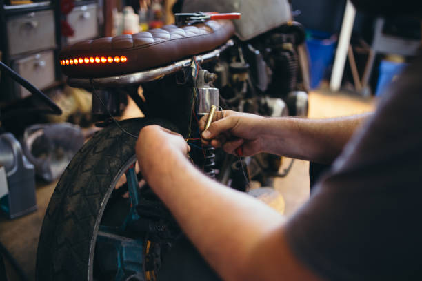 istock Man fixing electric wires on custom bike 972556818