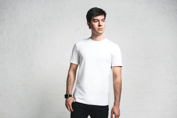 istock Young guy wearing blank white t-shirt, empty wall, horizontal studio portrait 972560116