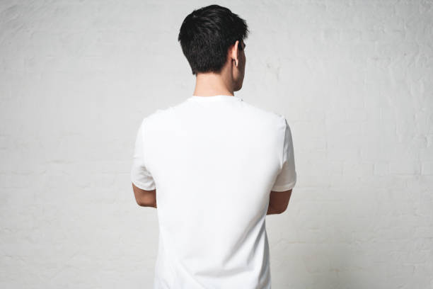 istock Young athletic guy in blank white t-shirt, back side, horizontal studio portrait, empty wall 972560242