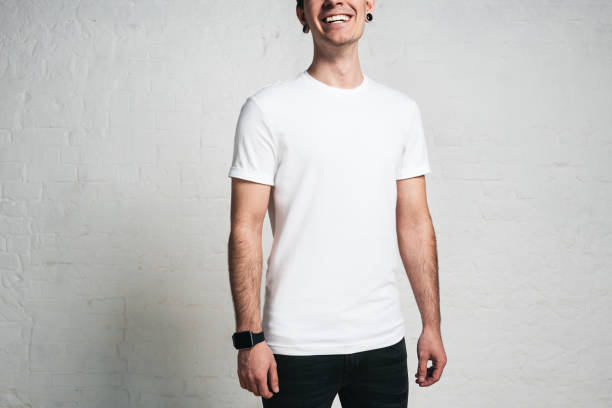 istock Young smiling guy in white blank t-shirt, horizontal studio portrait, empty wall 972561688