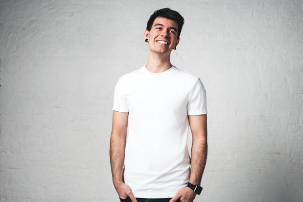 istock Smiling young man in blank white t-shirt, studio portrait 972562600