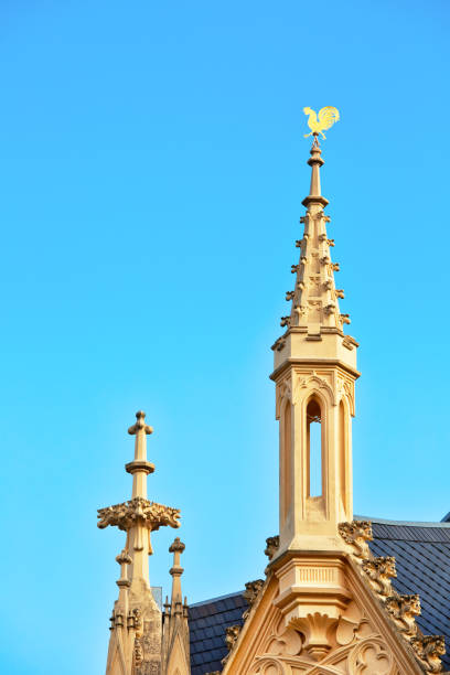 Rooster on a small tower against blue sky, architectural background