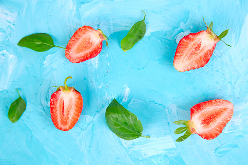 Strawberry and basil on blue background. Fruit frame. Summer concept. Flat lay, top view