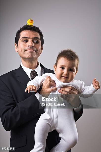 Traje De Hombre Usando Un Bebé Retención Foto de stock y más banco de imágenes de Foto de estudio - Foto de estudio, Niño, Padre