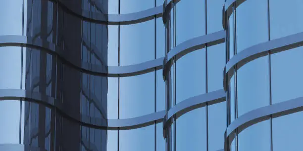 3D stimulate of high rise curve glass building and dark steel window system on blue clear sky background,Business concept of future architecture,lookup to the angle of the corner building.