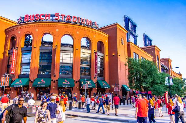 Sports fans outside of Busch Stadium in the evening St. Louis, MO—June 6, 2018 crowds walk outside of baseball stadium prior to game.  Busch Stadium is home to Major League Baseball’s Saint Louis Cardinals team. major league baseball stock pictures, royalty-free photos & images