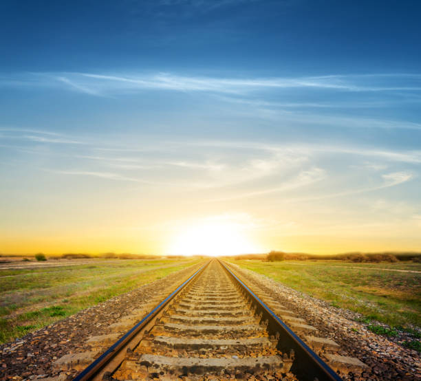 istock railroad among a green fields to a dramatic sunset 972590672