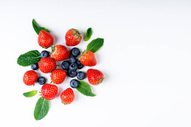 istock Fresh berries on white background, top view. Strawberry, blueberry and mint leaf 972596614