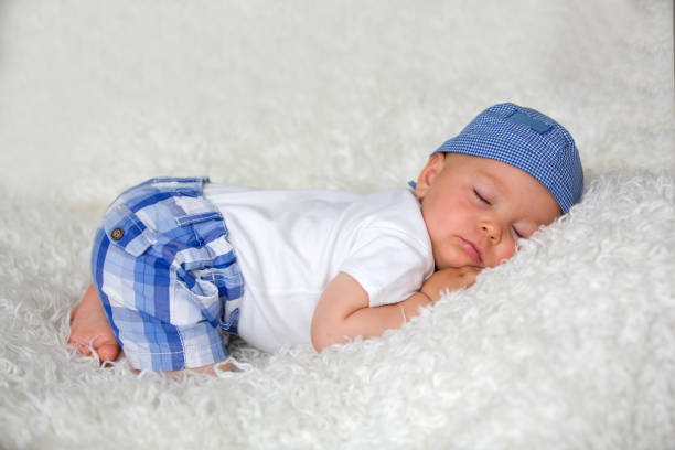 istock Cute baby boy, sleeping in bed with hat 972599334