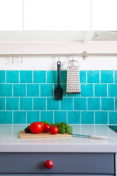istock Kitchen features dark gray flat front cabinets paired with white quartz countertops and a glossy blue care tile. 972603144
